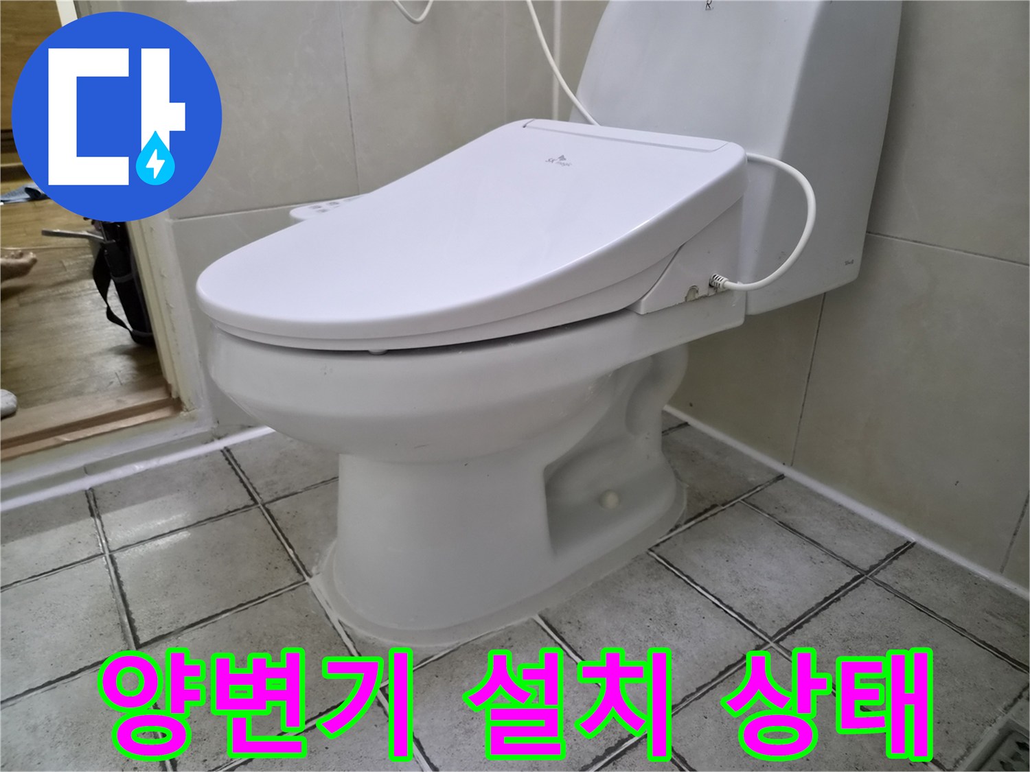 화장실 바닥에 설치된 하얀색 양변기와 타일 마감 상태
