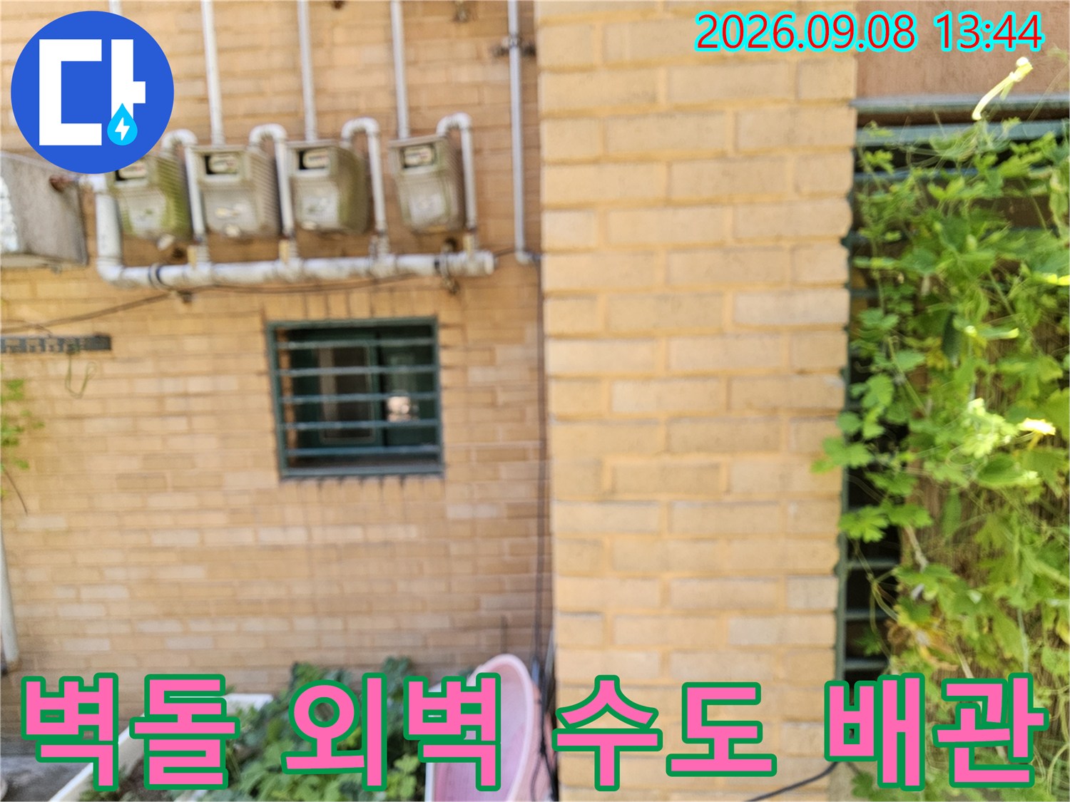 건물-외벽의-수도-계량기와-상단으로-연결된-배관들