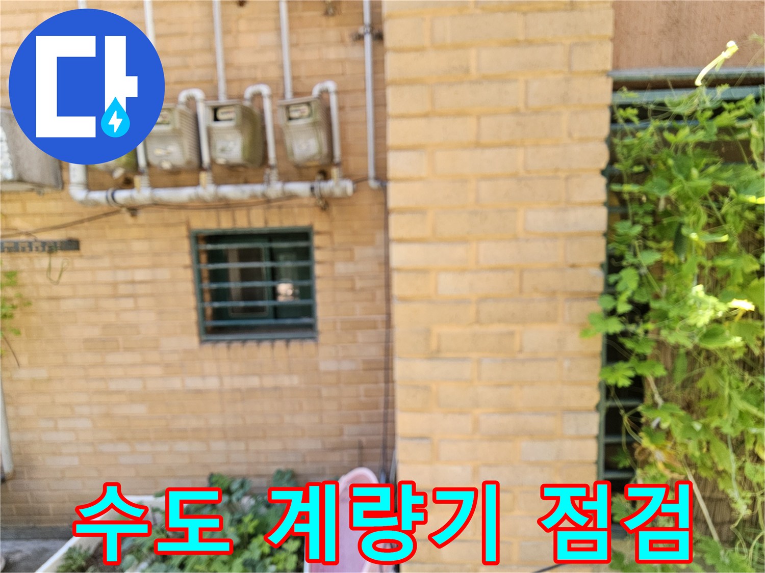 벽돌 벽면에 설치된 수도 계량기와 연결 배관입니다.
