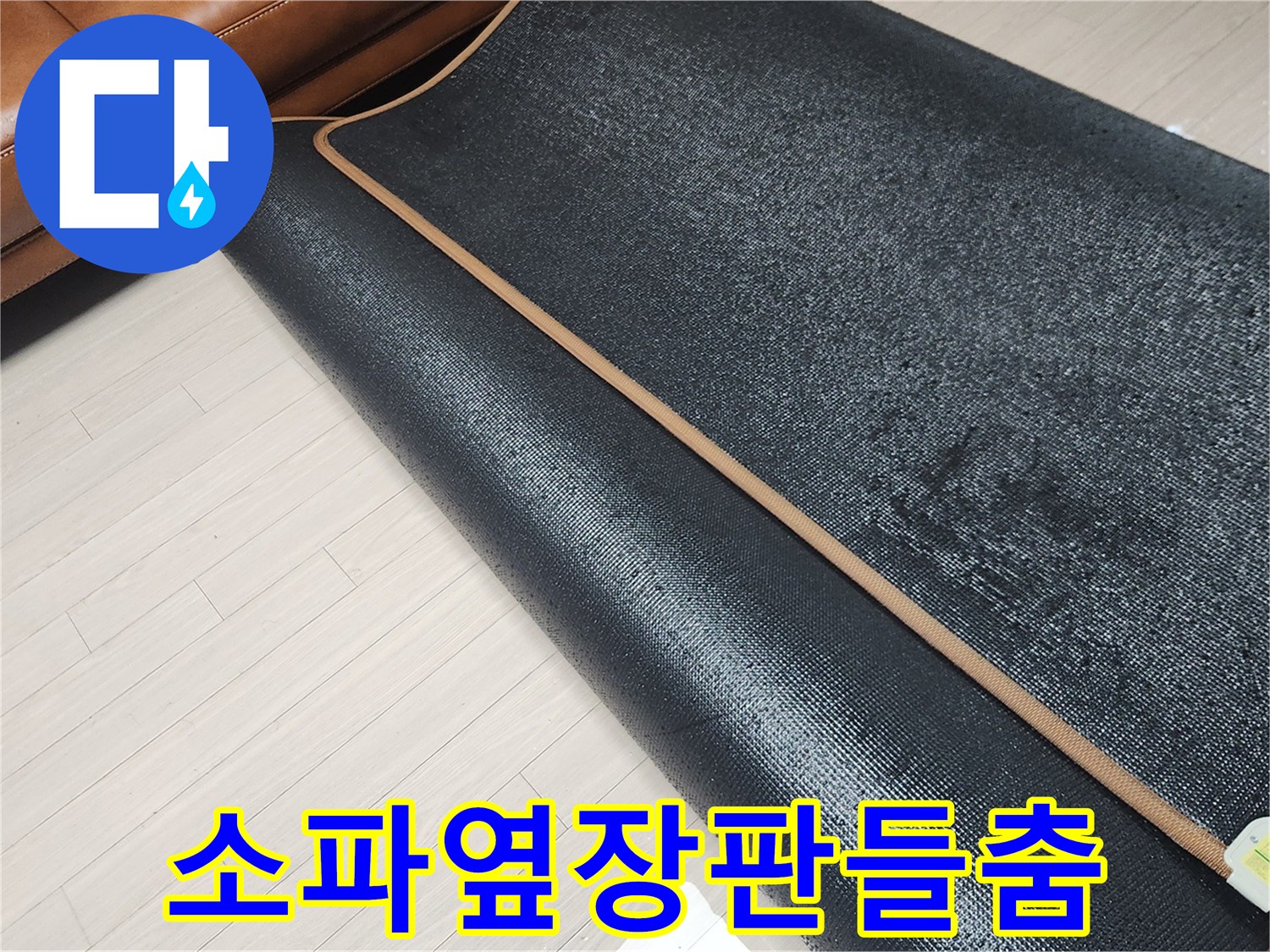 소파 옆쪽의 장판을 걷어내고 바닥 상태를 확인하는 모습입니다.
