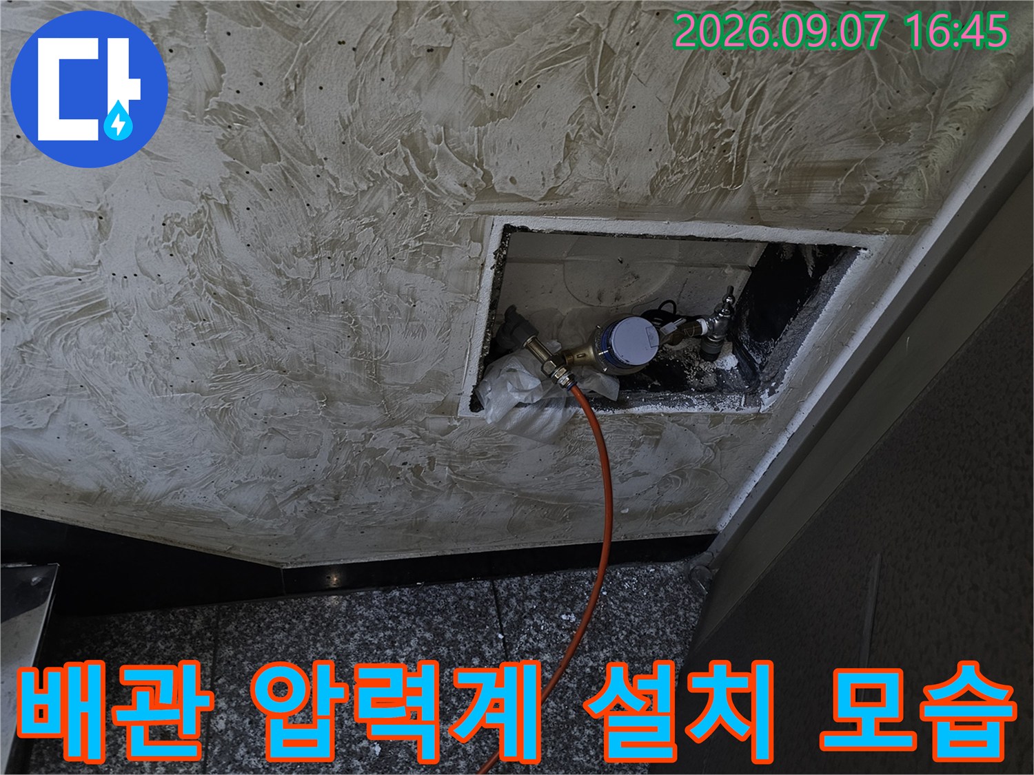 천장 배관 연결부-압력 테스트를 위해 게이지와 호스가 연결된 상태