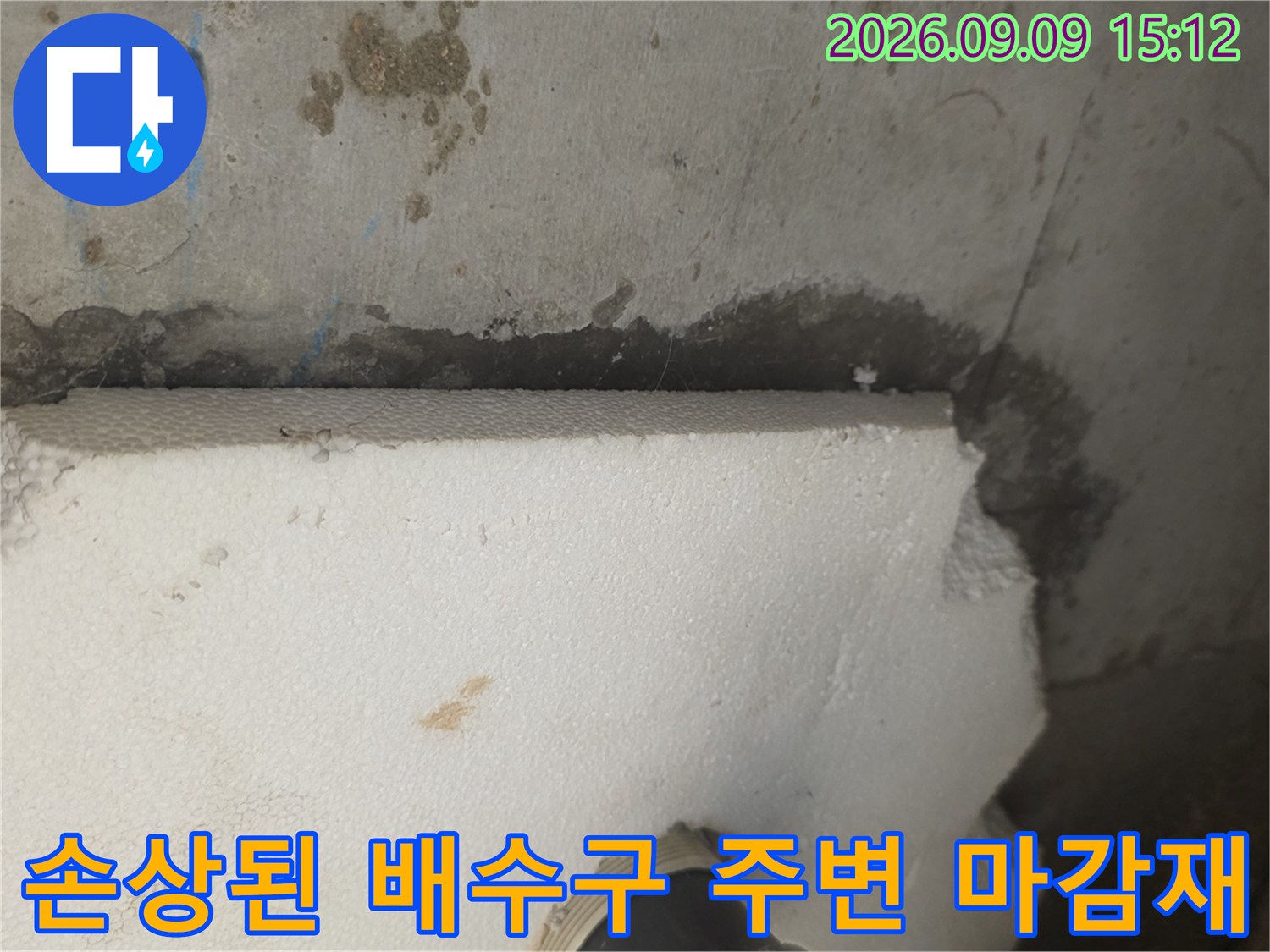 배수구 근처-물이 스며든 벽면과 손상된 자재의 모습입니다.