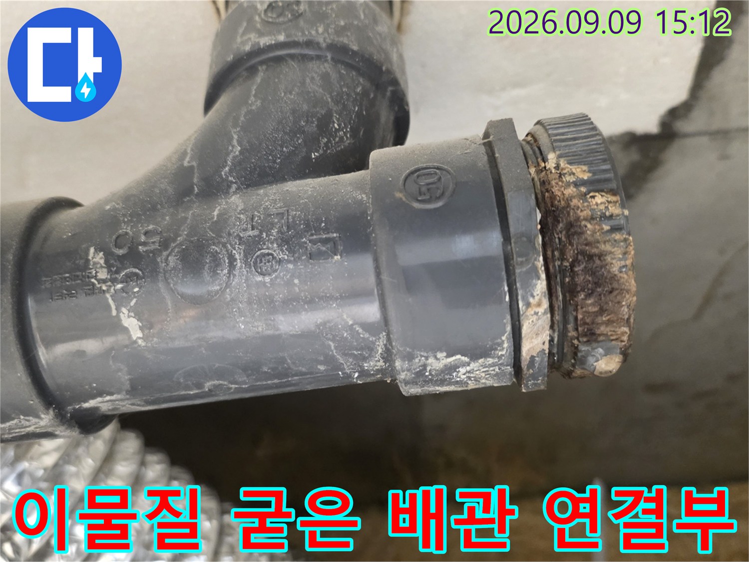 하수 배관 끝의 오염된 연결 부위를 보여주는 근접 사진입니다.