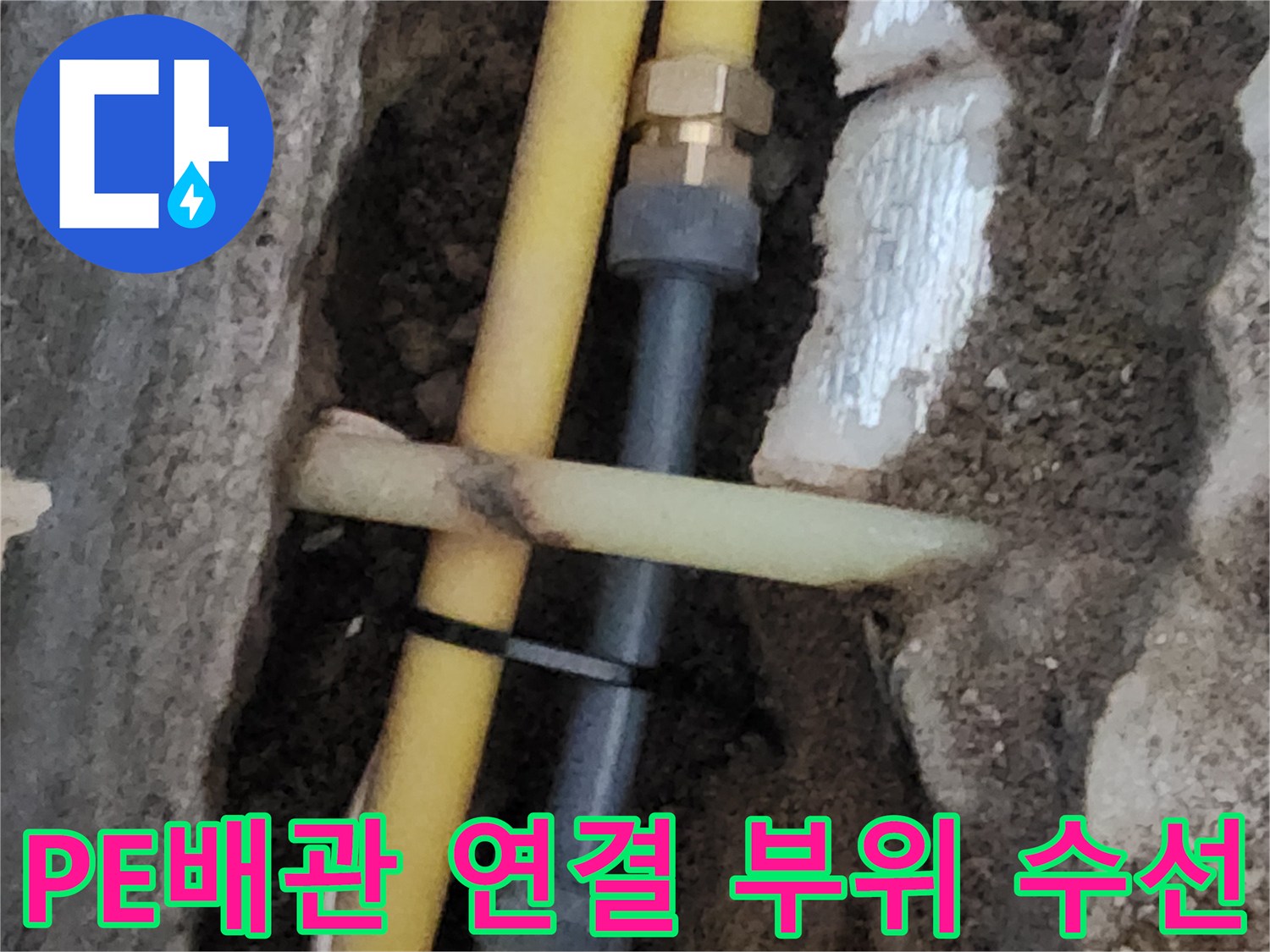 노란색 PE 배관과 금속 부속이 결합된 배관 수리 장면