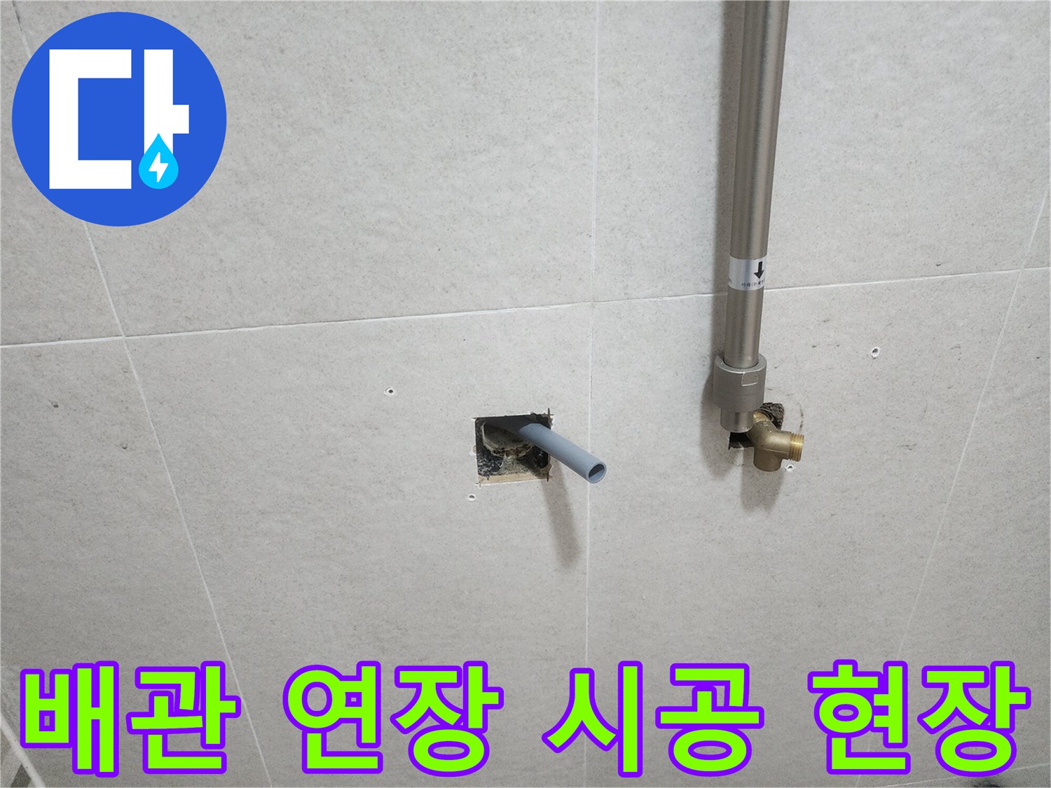 벽면 타일 틈새로 노출된 은색 스테인리스 배관 부위
