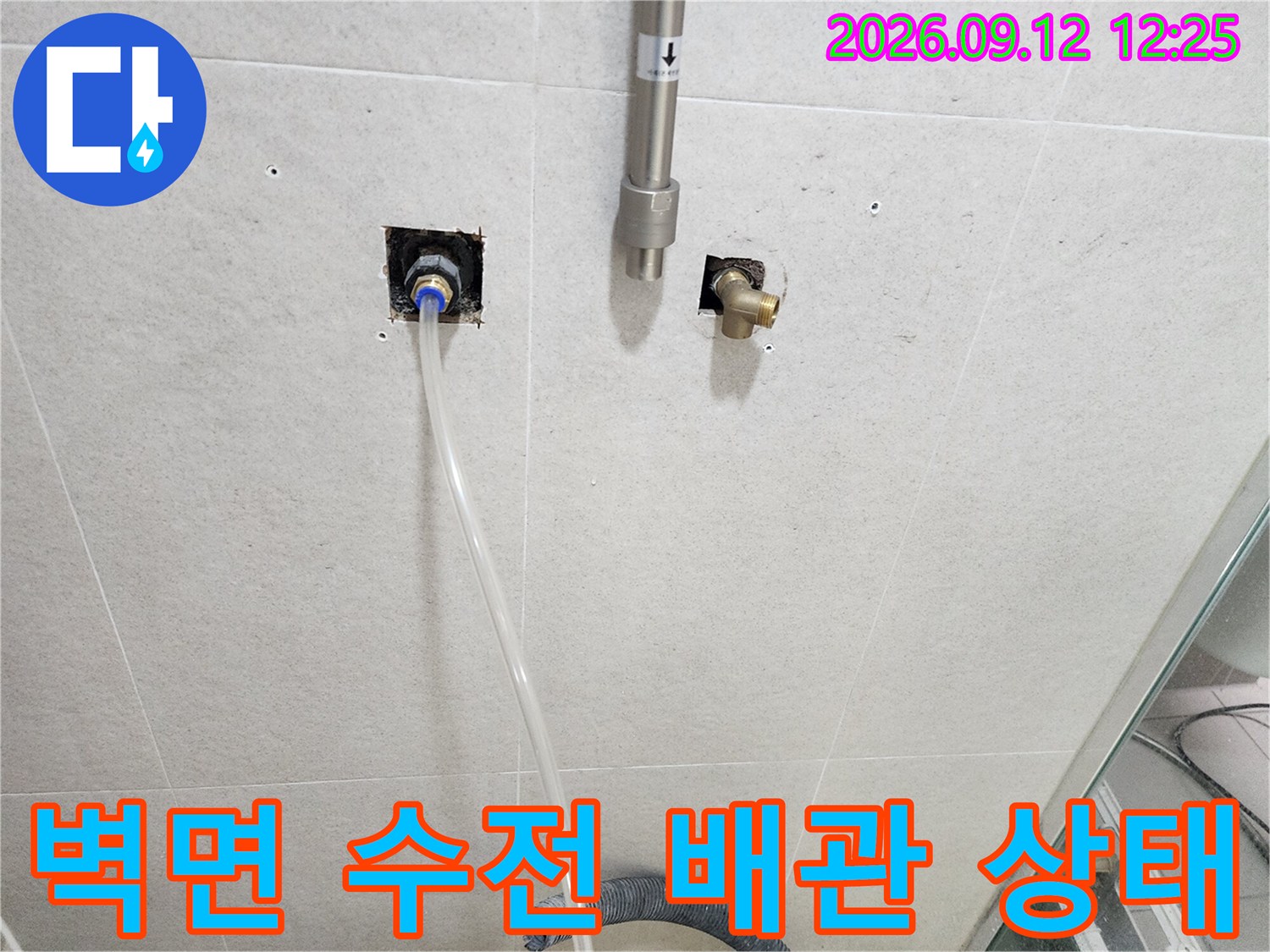 화장실 벽면에 노출된 수도 배관과 연결 부위의 누수 여부를 면밀히 관찰하고 있습니다.