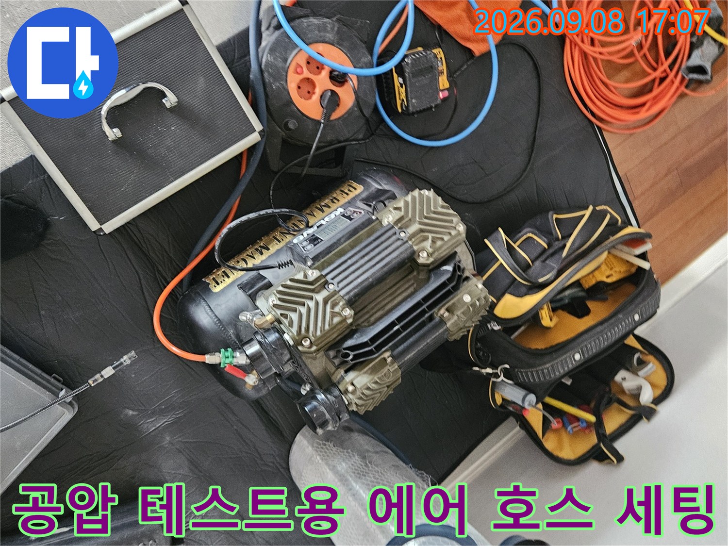 누수 탐지를 위해 배관과 연결할 주황색 에어 호스와 압축기 장비 배치-정밀 진단 준비