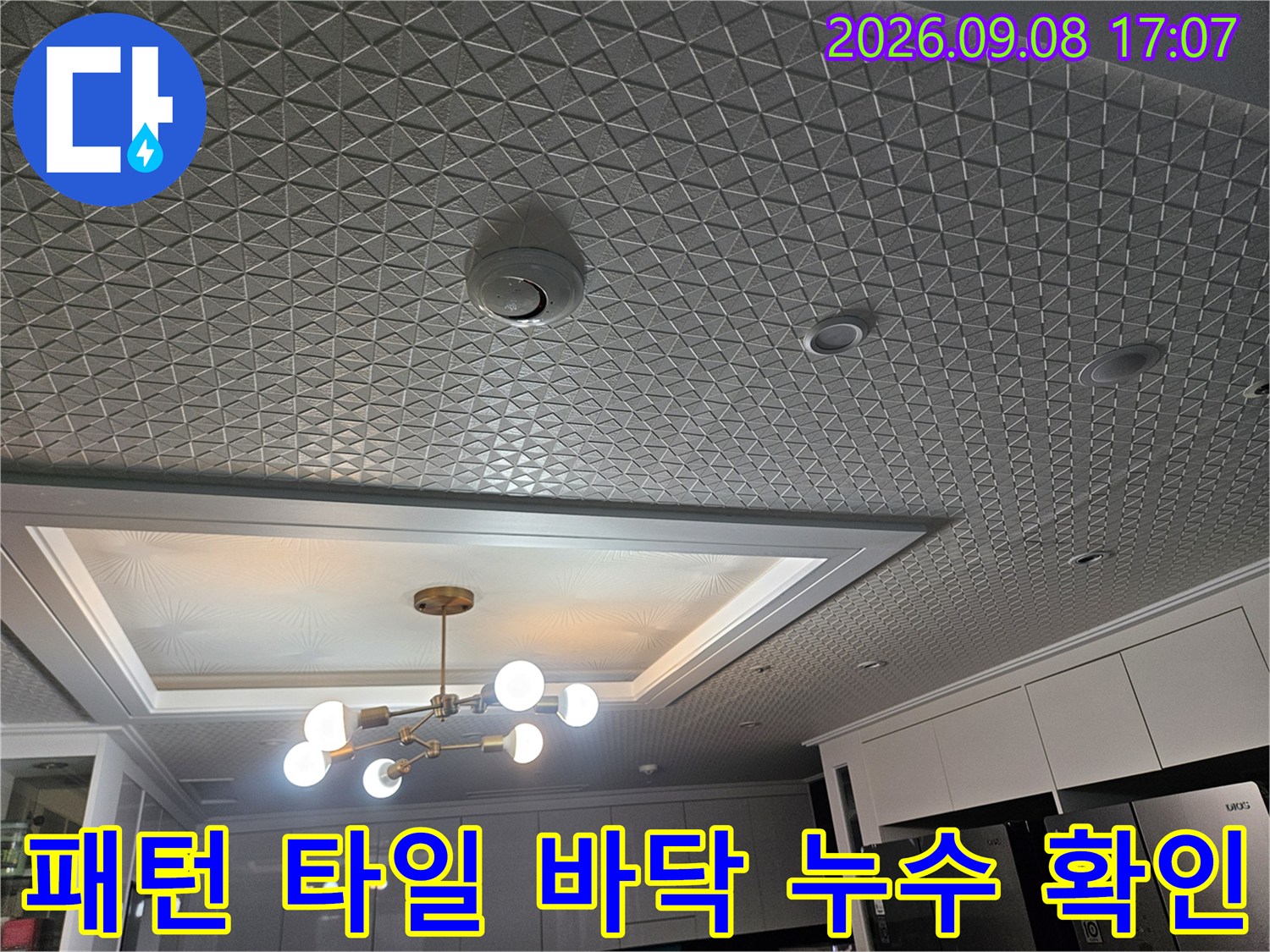 조명 아래 비춰진 세탁실의 격자 무늬 패턴 바닥재와 배수구 주변