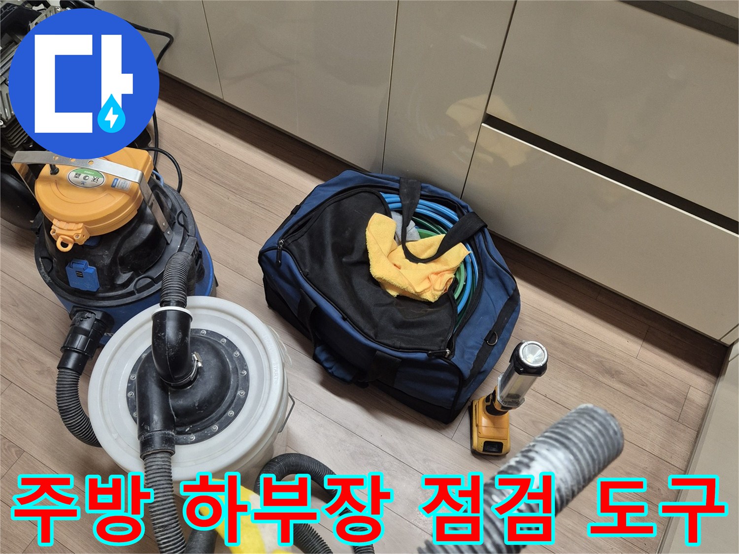 싱크대 하단 작업 공간에 놓인 공압 측정기와 청소용 진공 흡입기