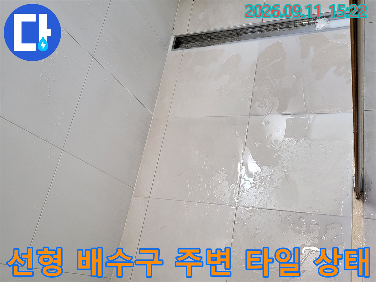 광진구 중곡동 욕실 내 선형 배수구와 타일 표면의 습기 상태를 보여주는 사진입니다.
