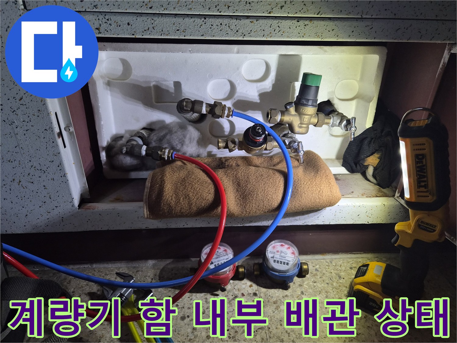 수도 계량기와 연결된 각종 밸브와 배관 부속품들이 배치된 모습