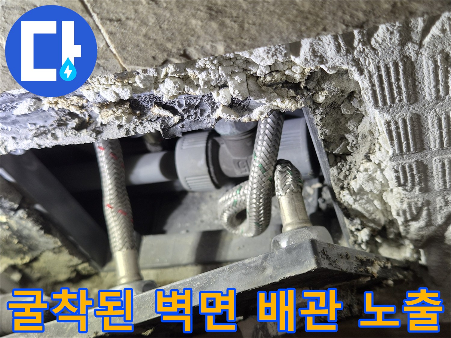 벽돌과 시멘트 사이로 드러난 꼬여있는 수전 연결 호스