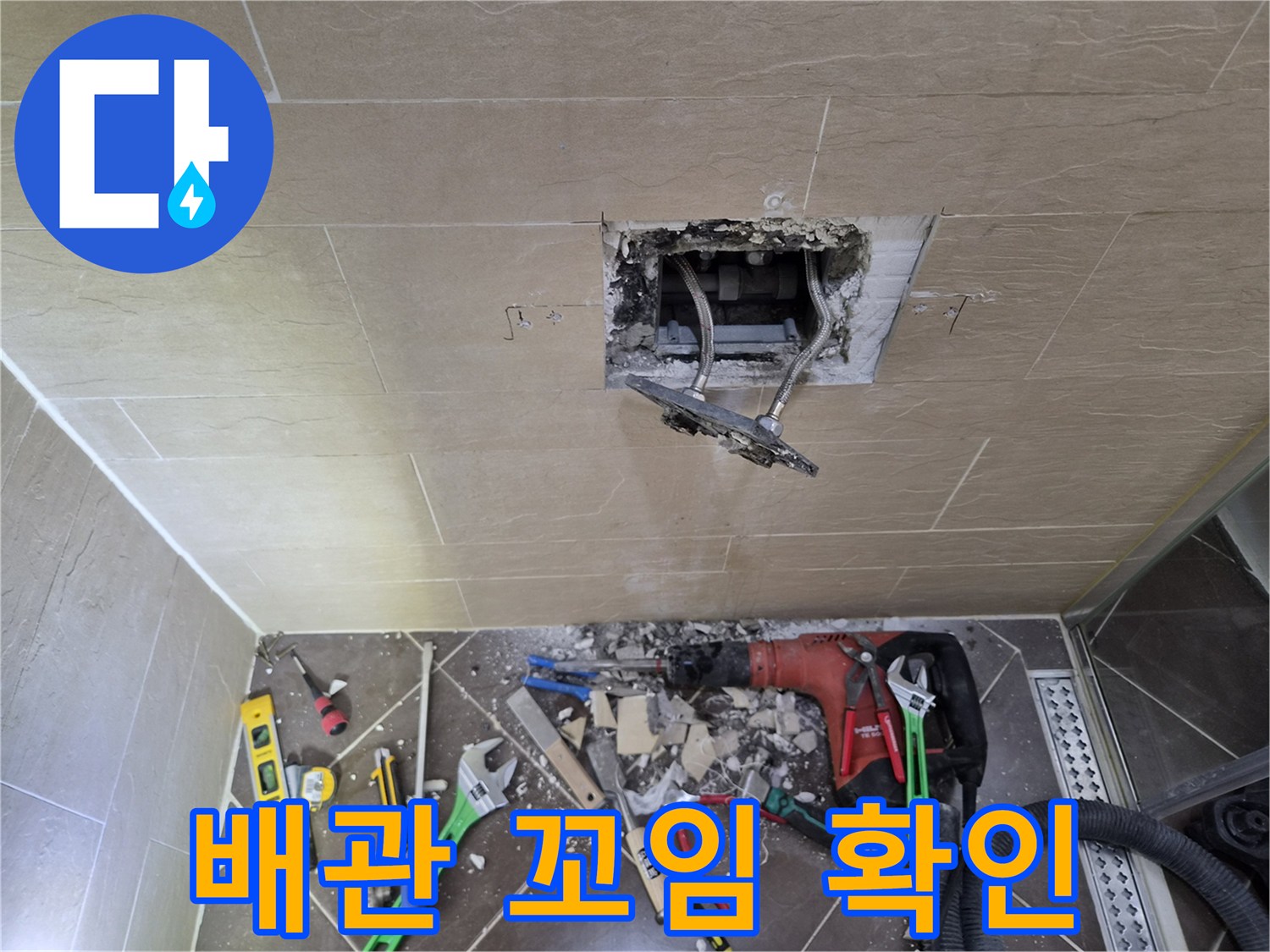 타일 제거 부위에 드러난 뒤틀린 형태의 샤워 수전 배관