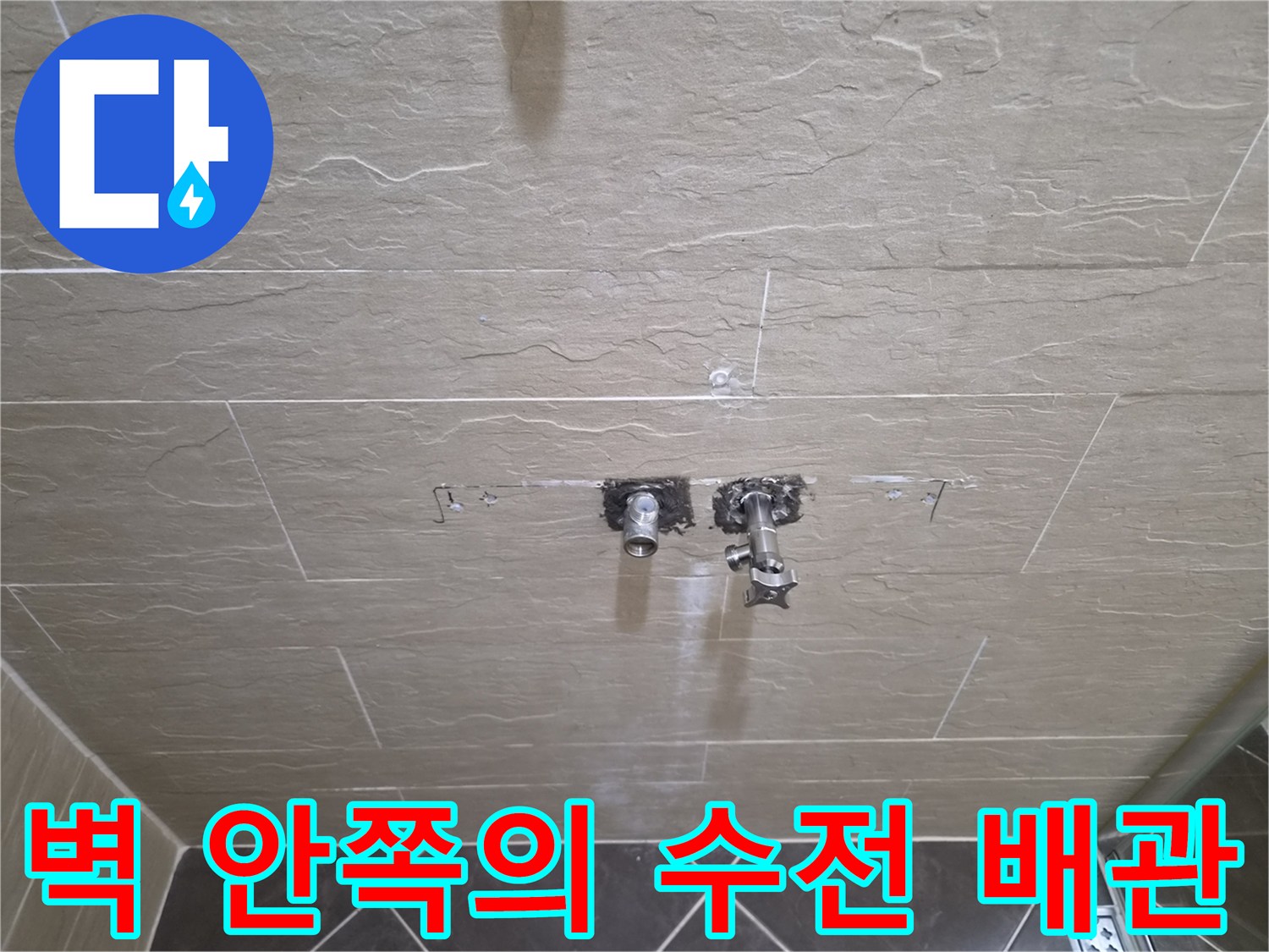 타일을 걷어내고 드러난 샤워기 연결 배관의 상세 모습입니다.