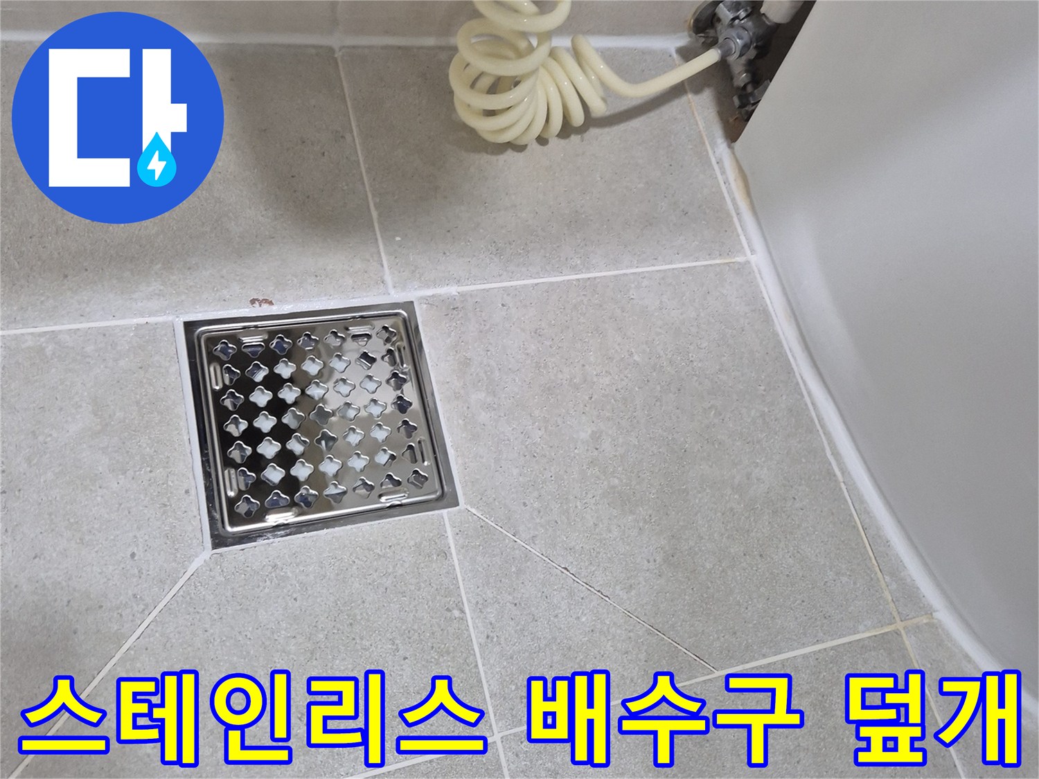 욕실 타일 바닥에 설치된 스테인리스 재질의 배수구 유가 모습입니다.