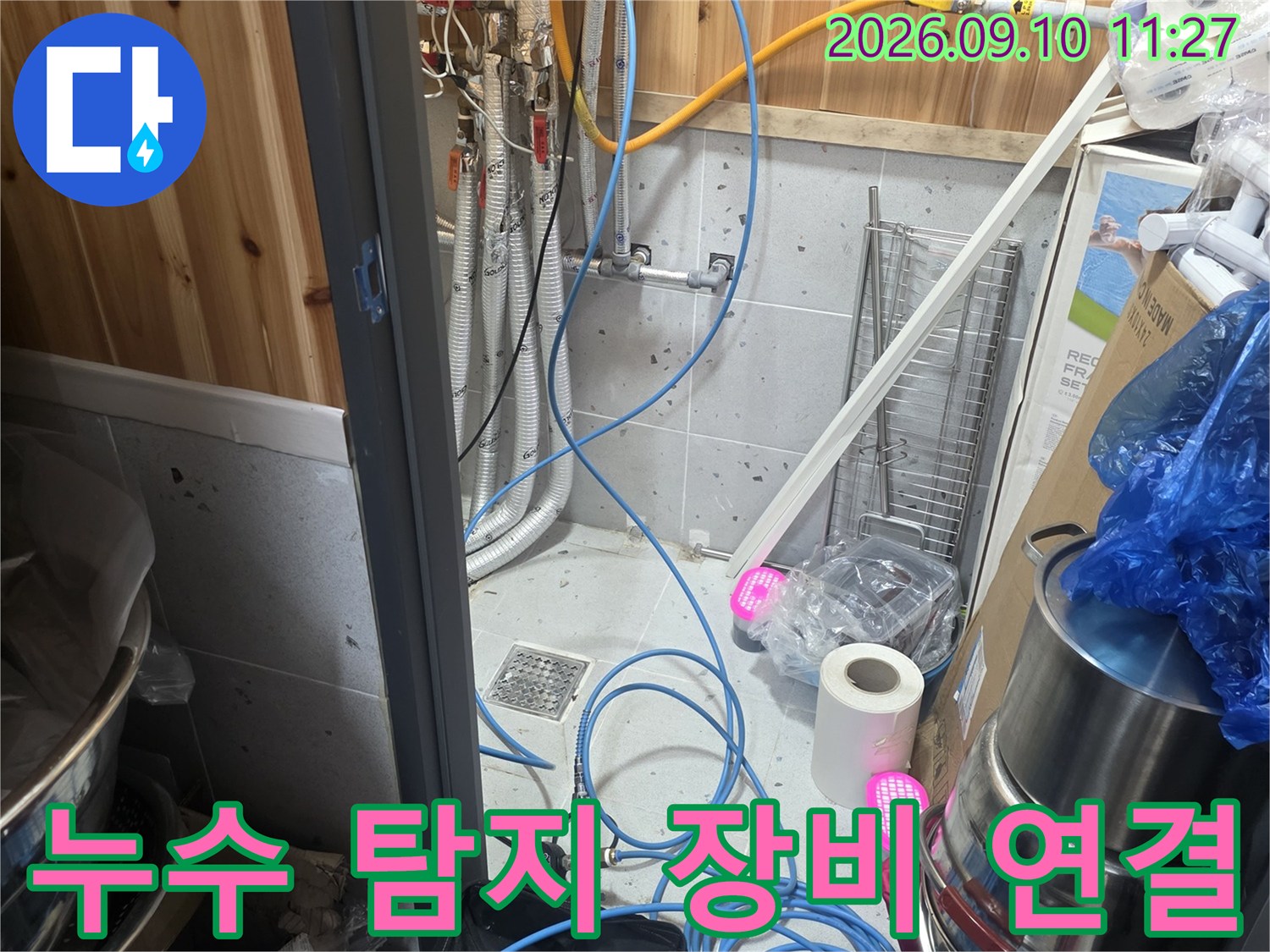 파란색 호스와 각종 배관 부속이 연결된 누수 탐지 작업 현장입니다.