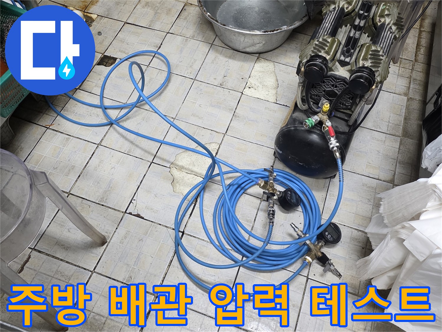 식당 주방 바닥에 놓인 공압 테스트용 질소 가스 장비와 파란색 호스