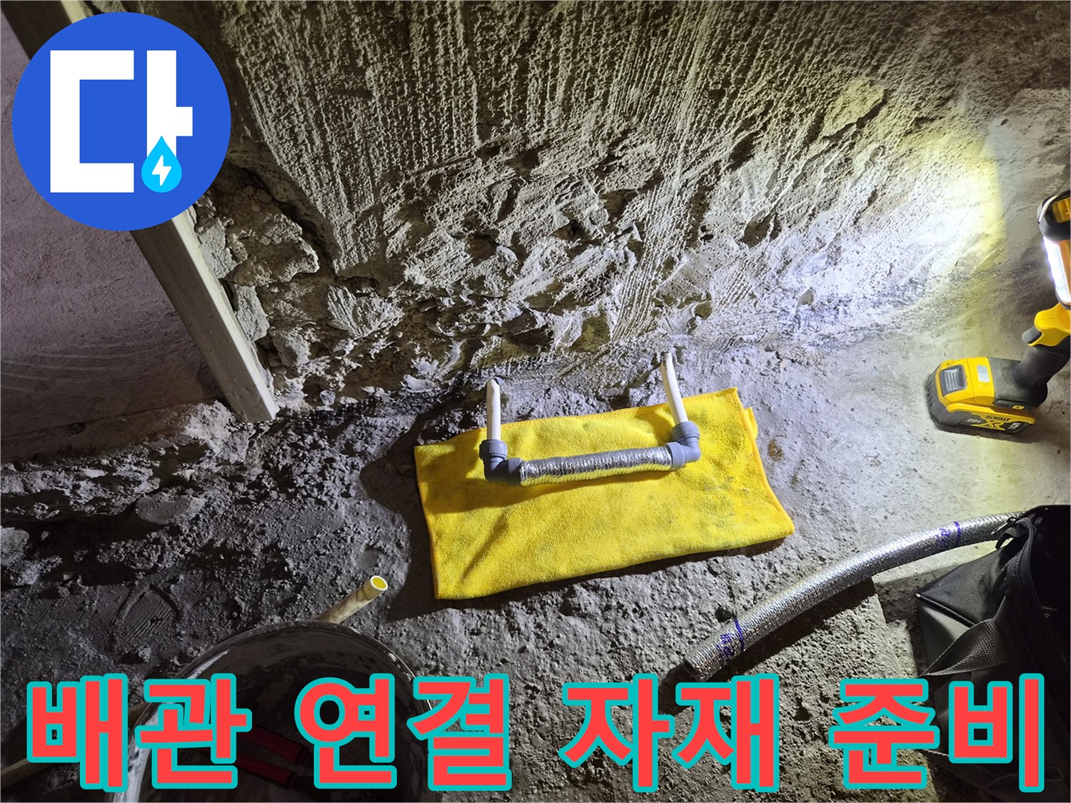 거친 콘크리트 굴착 부위와 노란색 보호재가 씌워진 배관