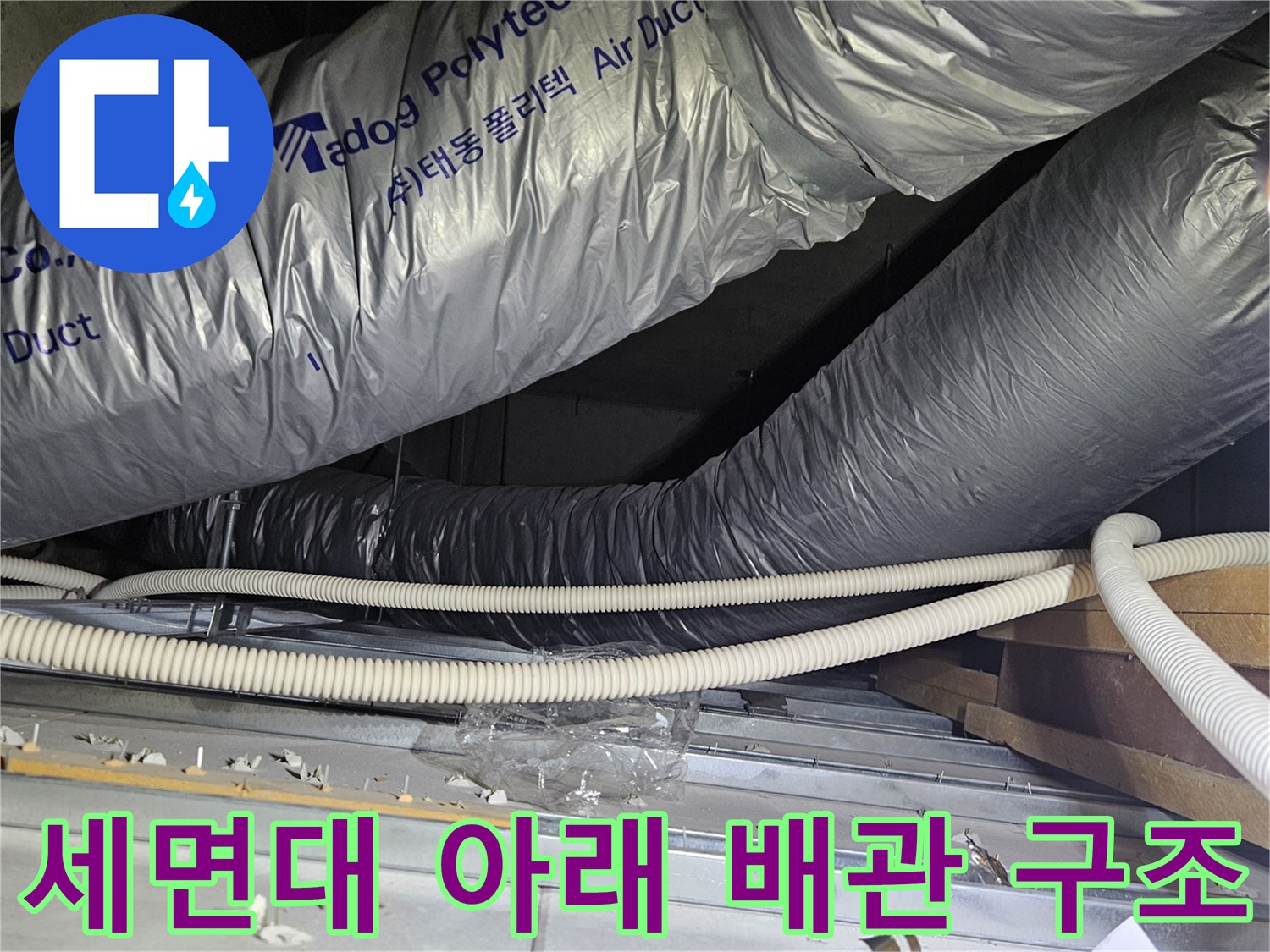 은색 보온재로 덮인 커다란 배관과 흰색 전선 관이 있는 현장 모습