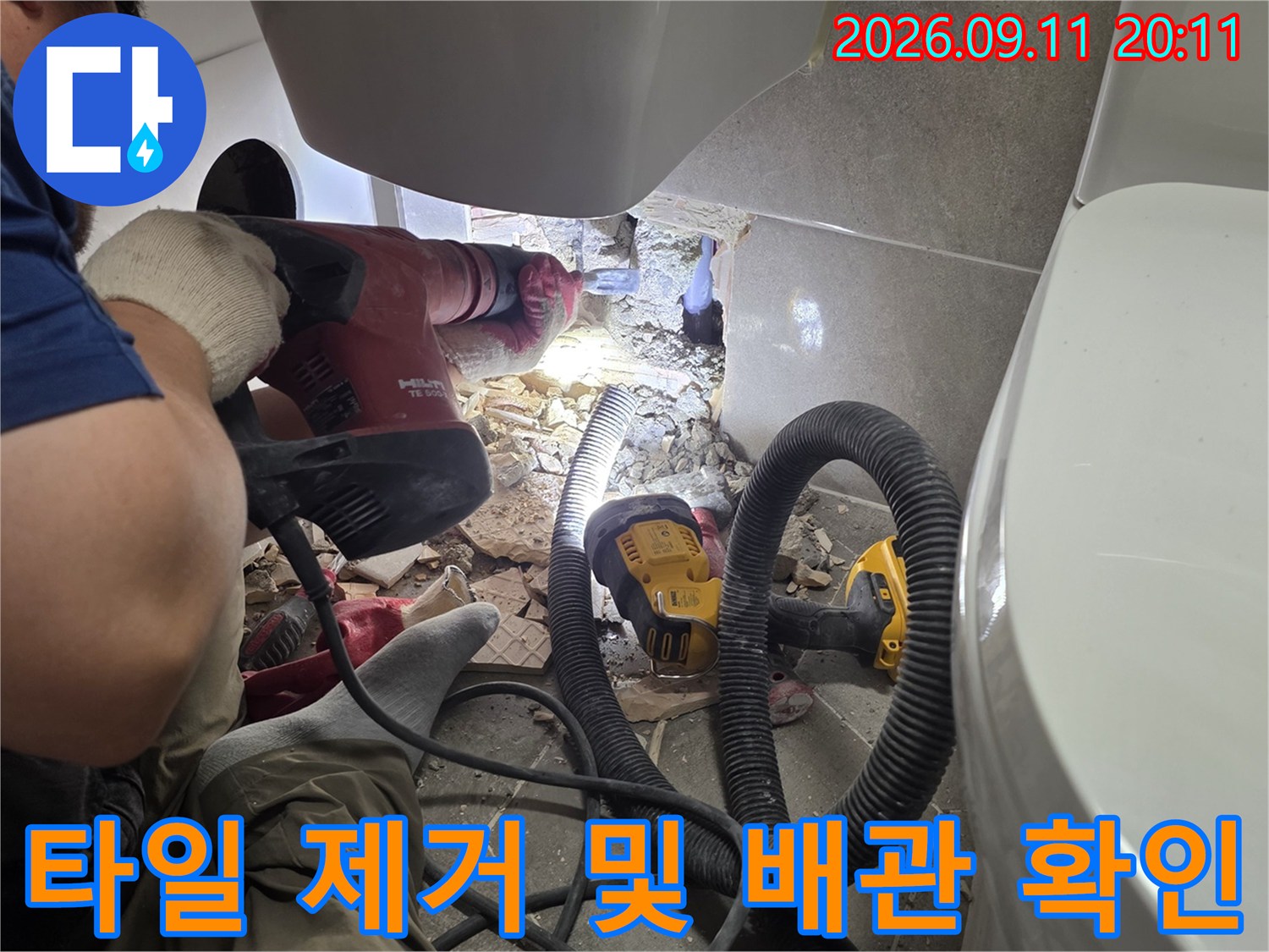 주안동 현장-세면대 아래 벽면 타일을 깨서 배관 누수 지점을 드러내는 장면입니다.