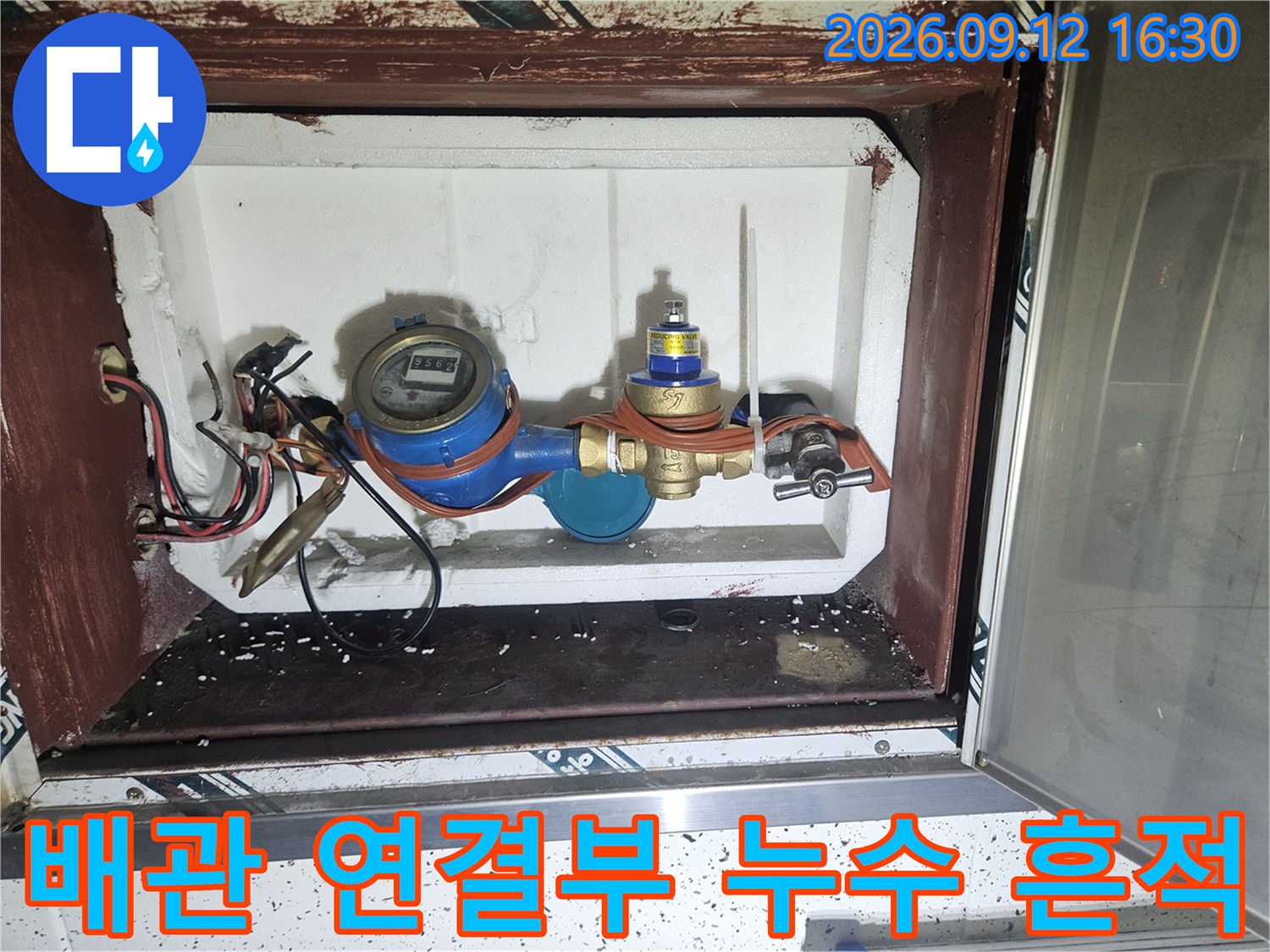 수도 계량기 주변의 배관 연결 부위와 습기 젖은 흔적
