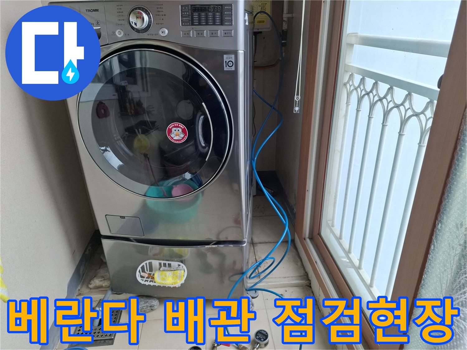 세탁기 옆 공간의 배수구와 압력 측정 호스 모습입니다.