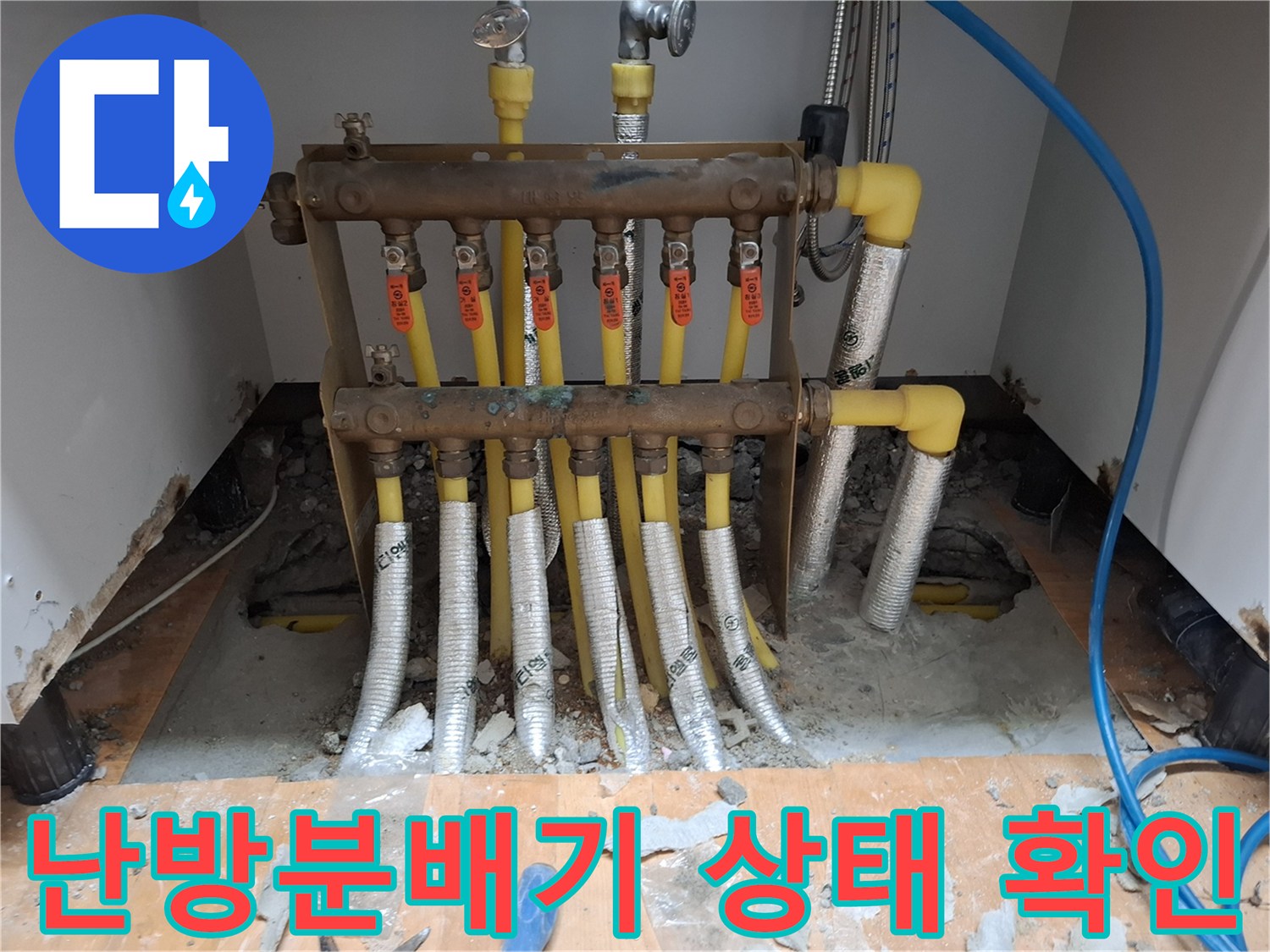 싱크대 하부장에 위치한 난방 분배기와 노란색 엑셀 배관의 모습입니다.