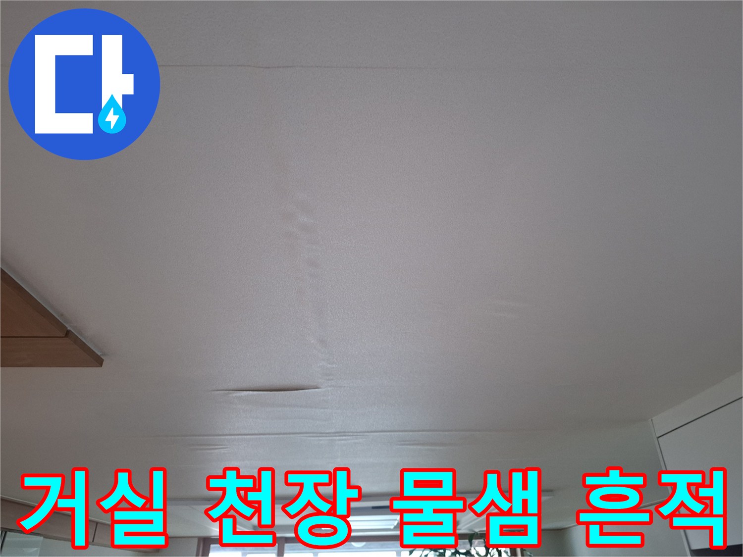 아랫집 거실 중앙 천장에 발생한 습기와 얼룩 상태를 보여주는 사진입니다.