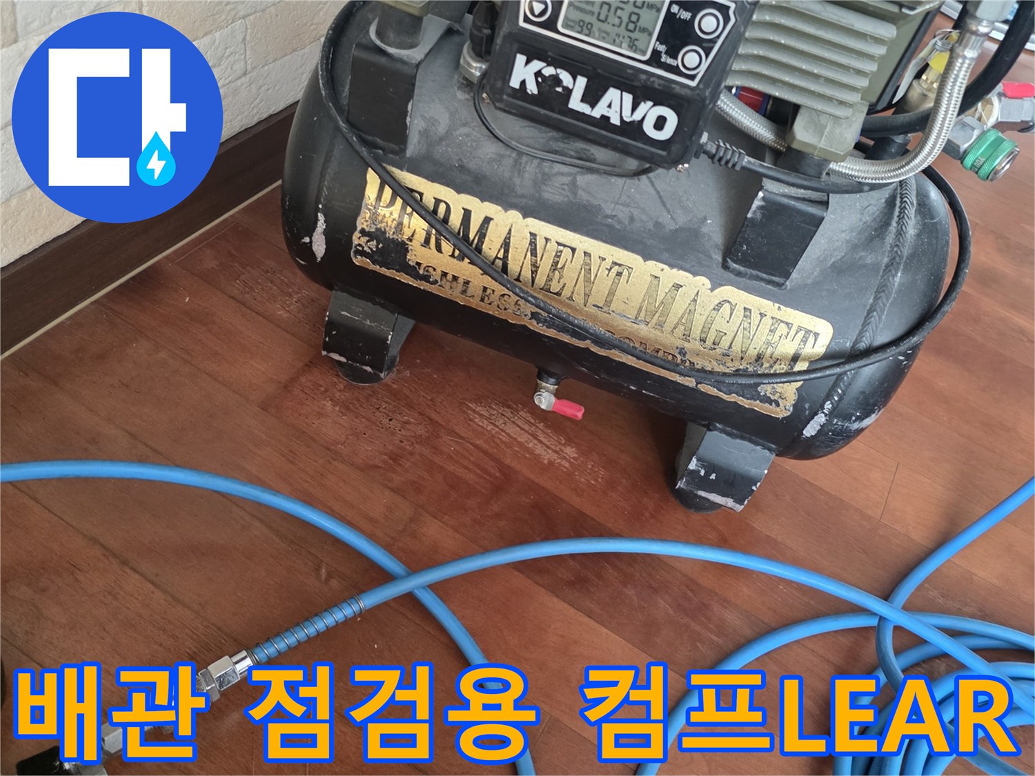 현장 바닥에 놓인 에어 컴프레서와 파란색 고압 호스 연결 상태