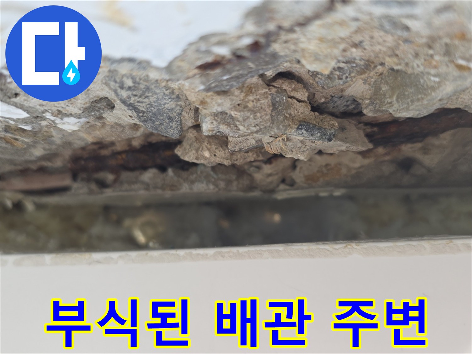 배관 연결 부위 근처의 콘크리트가 젖어 있고 파손된 사진
