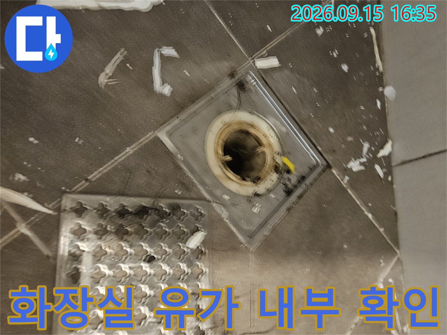유가 덮개를 옆으로 밀어둔-배수구 안쪽의 노출된 배관 모습