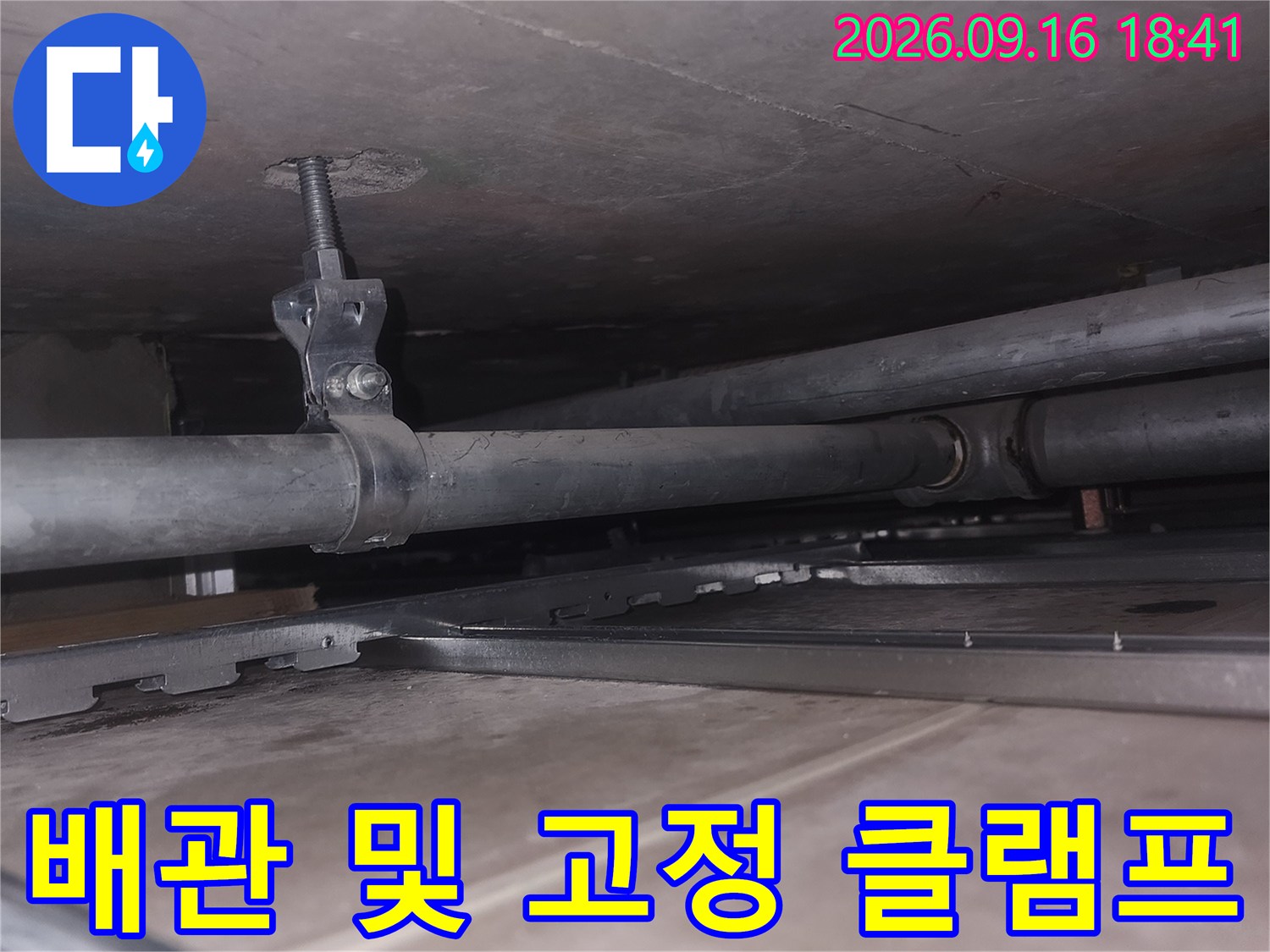 천장 내부의 수직 배관과 금속 고정 장치