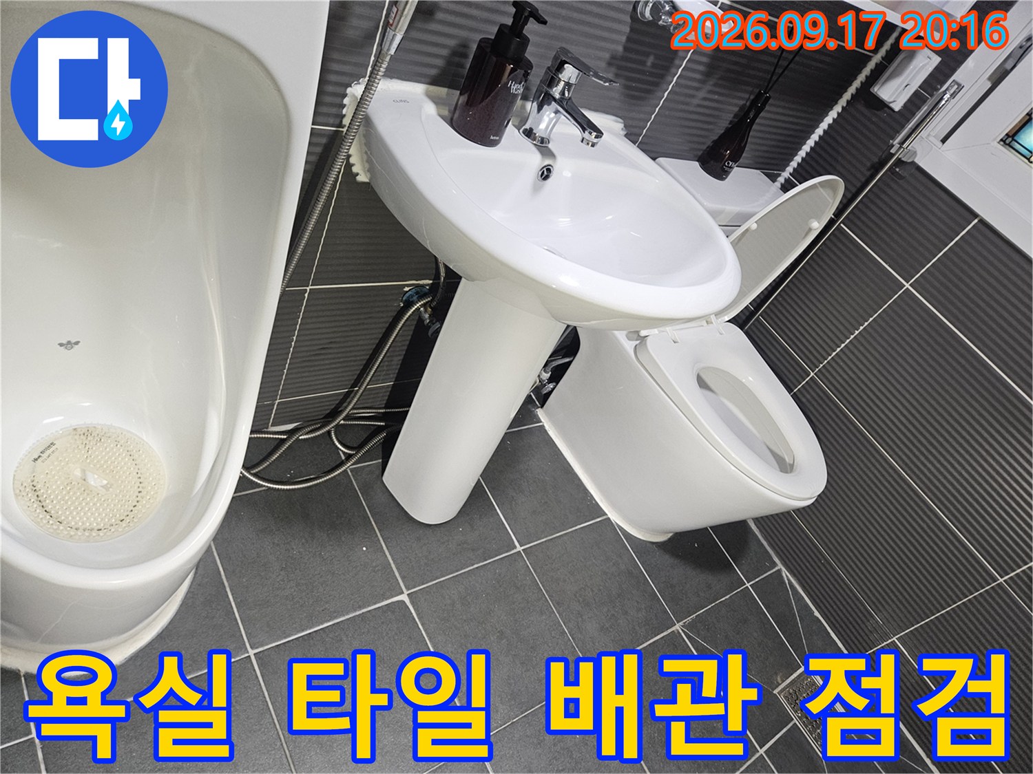 회색 타일 벽면과 변기 주변의 배관 연결 상태 상세 사진