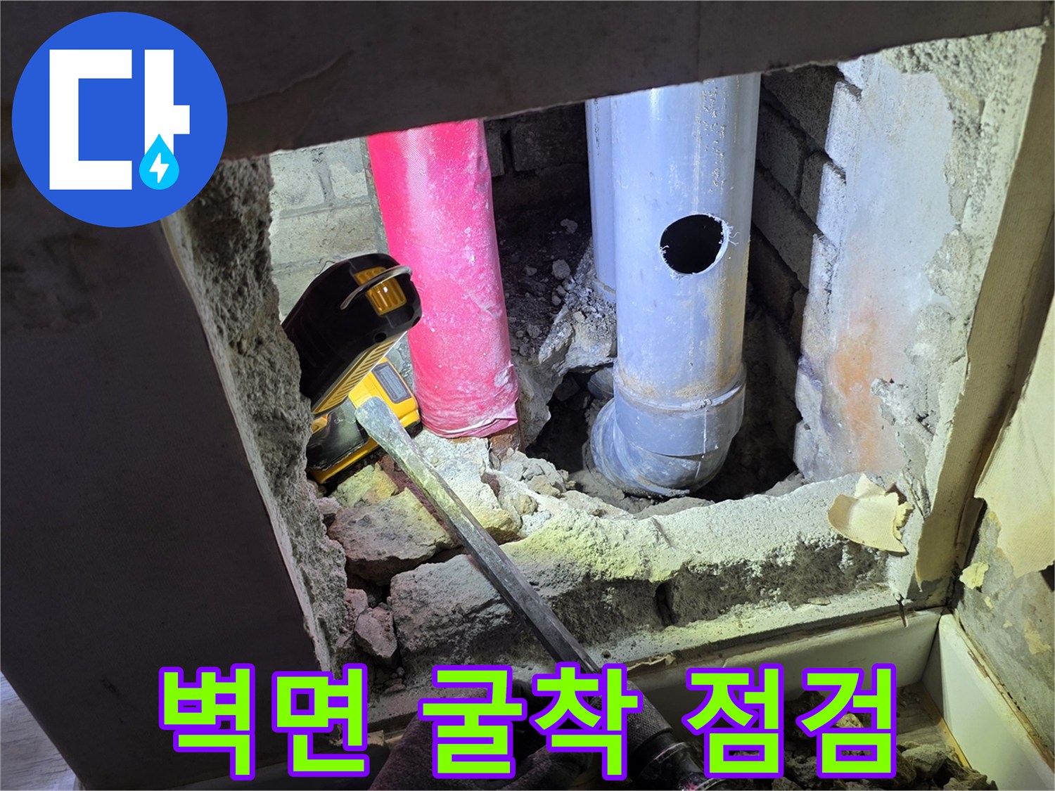 함마드릴로 벽을 뚫어 노출시킨 배관과 주변 잔해물