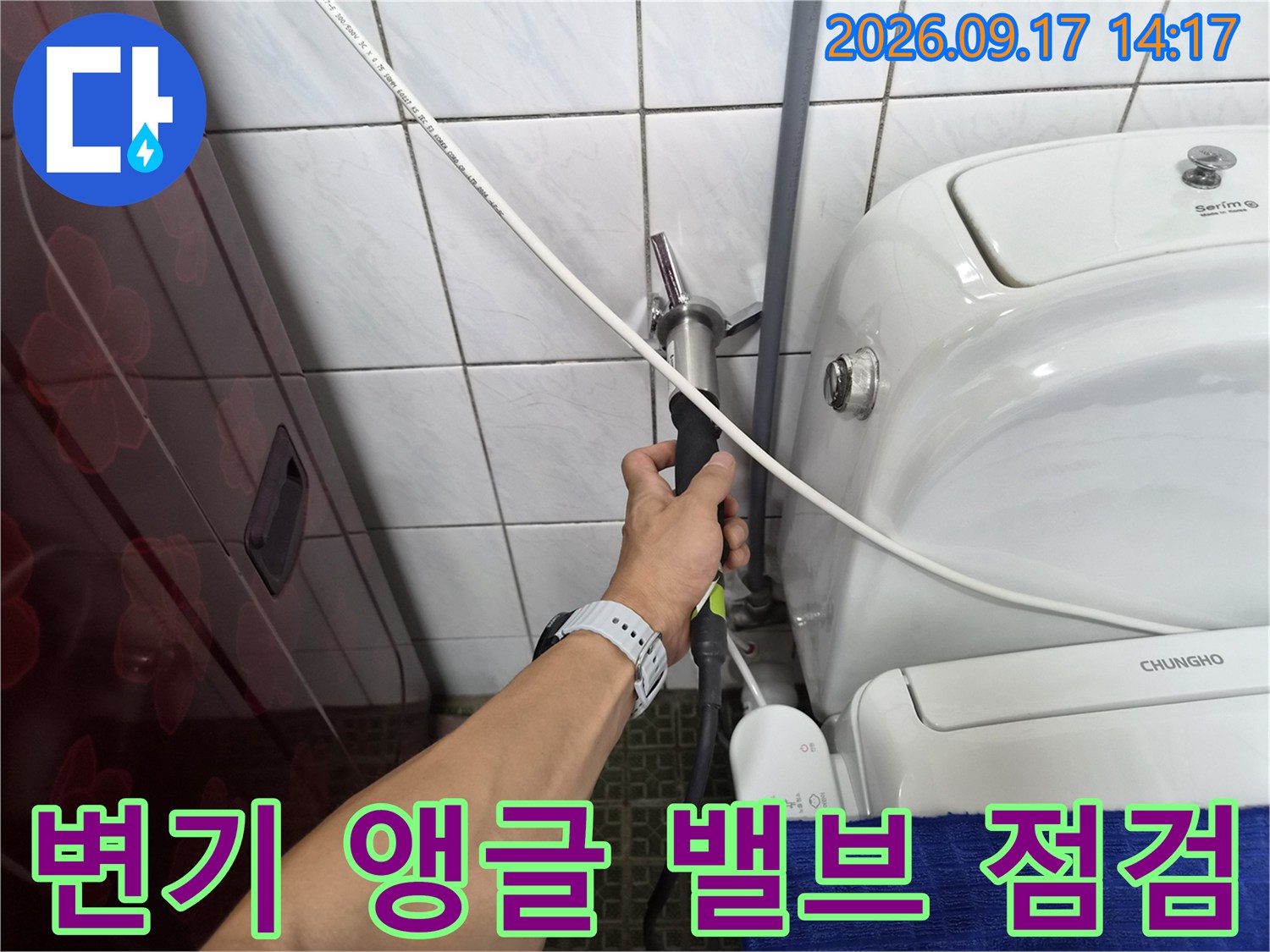 변기 뒤쪽 벽면 배관 밸브와 호스 연결 부위를 손으로 확인하는 엔지니어