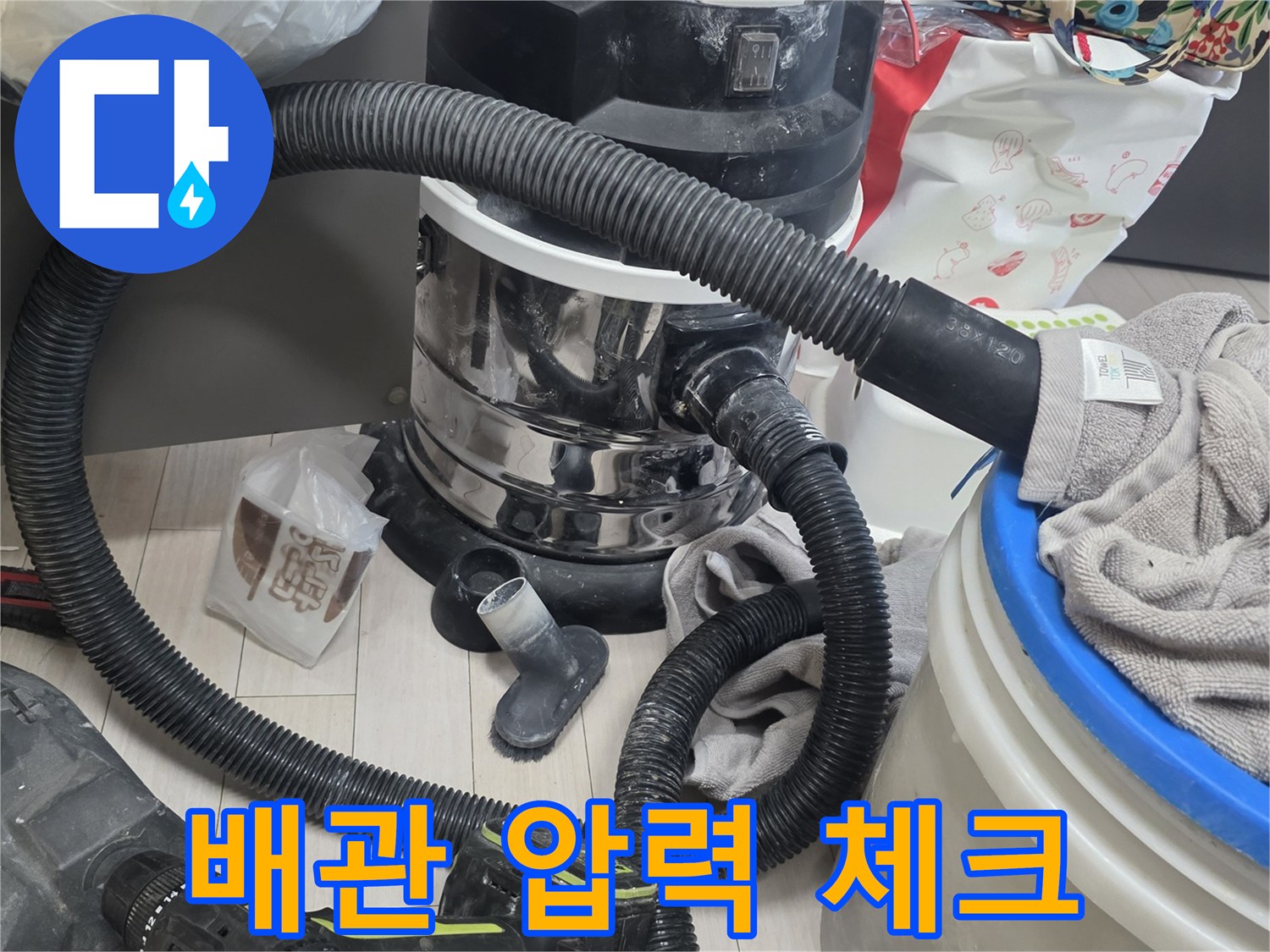 싱크대 하단 배관에 연결된 검은색 공압 호스와 측정 장비의 모습